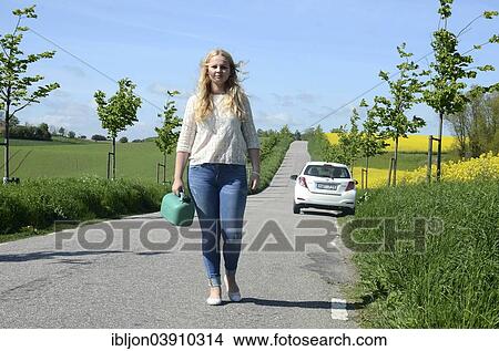 "Woman walking away from her car carrying a petrol can, Skane, Sweden, Europe" View Large Photo Image Picture - "Woman walking away from her car carrying a petrol can, Skane, Sweden, Europe". Fotosearch
