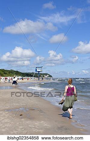 Stock Photo - "Woman walking on the beach, Bansin, Usedom Island, Mecklenburg-Western Pomerania, Germany, Europe". Fotosearch