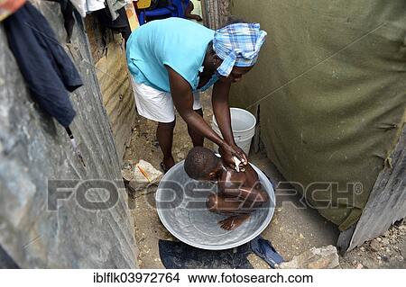 "Woman washing a boy outside her hut, Camp Icare, camp for earthquake refugees, Fort National, Port-au-Prince, Haiti, North America" View Large Photo Image Picture - "Woman washing a boy outside her hut, Camp Icare, camp for earthquake refugees, Fort National, Port-au-Prince, Haiti, North America". Fotosearch