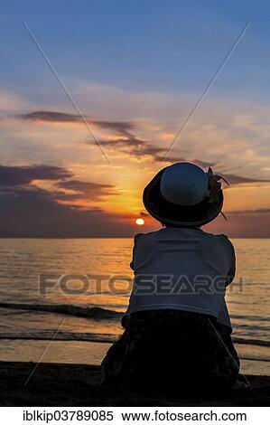 Stock Photography - "Woman watching the sunset, Lovina Beach, northwestern Bali, Bali, Indonesia, Asia". Fotosearch