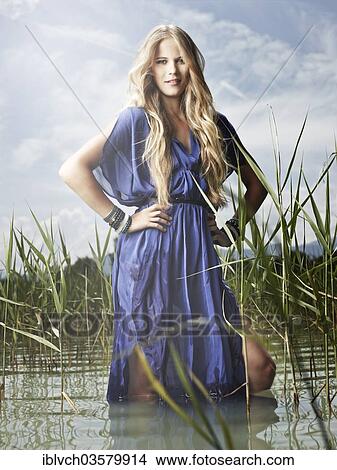 "Woman wearing a blue dress standing between the reeds, fashion, Lake Achen, Maurach, Tyrol, Austria, Europe" View Large Photo Image Picture - "Woman wearing a blue dress standing between the reeds, fashion, Lake Achen, Maurach, Tyrol, Austria, Europe". Fotosearch