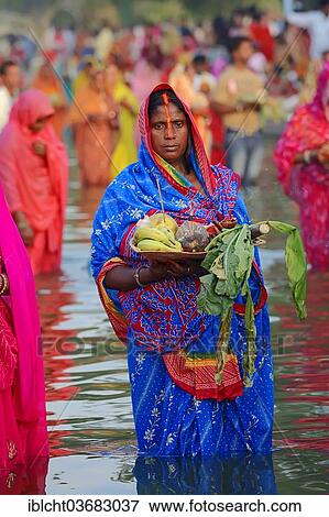 "Woman wearing a blue sari with offerings standing in water during the Hindu Chhath Festival, New Delhi, Delhi, India, Asia" View Large Photo Image Stock Photo - "Woman wearing a blue sari with offerings standing in water during the Hindu Chhath Festival, New Delhi, Delhi, India, Asia". Fotosearch