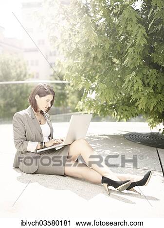 "Woman wearing a business suit sitting with a laptop in the park, Innsbruck, Tyrol, Austria, Europe" View Large Photo Image Stock Image - "Woman wearing a business suit sitting with a laptop in the park, Innsbruck, Tyrol, Austria, Europe". Fotosearch