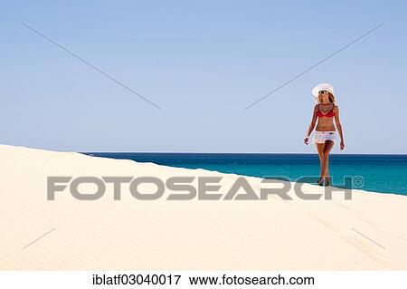 "Woman wearing a hat and a bikini walking along a sandy beach, Sotavento, Costa Bahia, Costa Calma, Fuerteventura, Canary Islands, Spain, Europe" View Large Photo Image Stock Photo - "Woman wearing a hat and a bikini walking along a sandy beach, Sotavento, Costa Bahia, Costa Calma, Fuerteventura, Canary Islands, Spain, Europe". Fotosearch