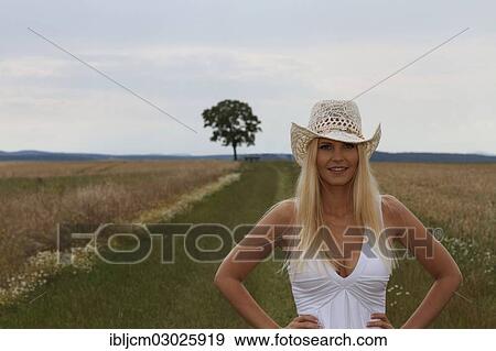 Stock Photo - "Woman wearing a hat, standing in a rural landscape, Thuringer Becken, Thuringer Wald, Thuringia, Germany, Europe". Fotosearch