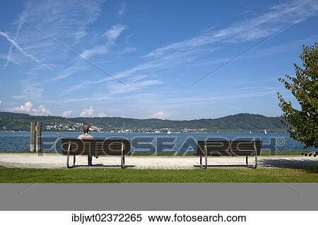 "Woman wearing a headscarf sitting on a bench on the shore of Lake Constance, Bodman, Baden-Wuerttemberg, Germany, Europe" View Large Photo Image Stock Photography - "Woman wearing a headscarf sitting on a bench on the shore of Lake Constance, Bodman, Baden-Wuerttemberg, Germany, Europe". Fotosearch