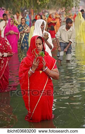 "Woman wearing a red sari with offerings standing in water during the Hindu Chhath Festival, New Delhi, Delhi, India, Asia" View Large Photo Image Stock Image - "Woman wearing a red sari with offerings standing in water during the Hindu Chhath Festival, New Delhi, Delhi, India, Asia". Fotosearch