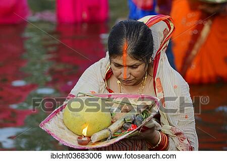 Stock Photograph - "Woman wearing a sari with offerings during the Hindu Chhath Festival, New Delhi, Delhi, India, Asia". Fotosearch