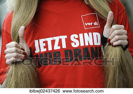 "Woman wearing a t-shirt, Jetzt sind wir dran!, German for Now it's our turn!, collective bargaining for more salary, Verdi trade union, bargaining-round during a retail strike, Germany, Europe" View Large Photo Image Stock Photograph - "Woman wearing a t-shirt, Jetzt sind wir dran!, German for Now it's our turn!, collective bargaining for more salary, Verdi trade union, bargaining-round during a retail strike, Germany, Europe". Fotosearch