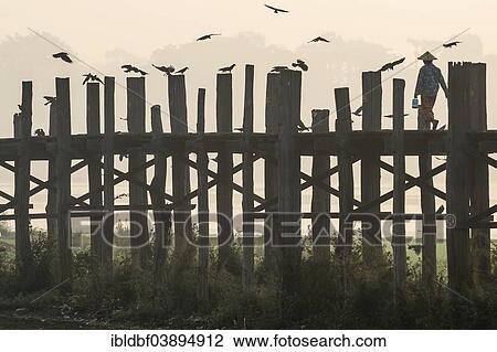 "Woman wearing a traditional hat on a teak bridge, U Bein Bridge over Taungthaman Lake, in the morning light, Amarapura, Mandalay Division, Myanmar, Asia" View Large Photo Image Stock Image - "Woman wearing a traditional hat on a teak bridge, U Bein Bridge over Taungthaman Lake, in the morning light, Amarapura, Mandalay Division, Myanmar, Asia". Fotosearch