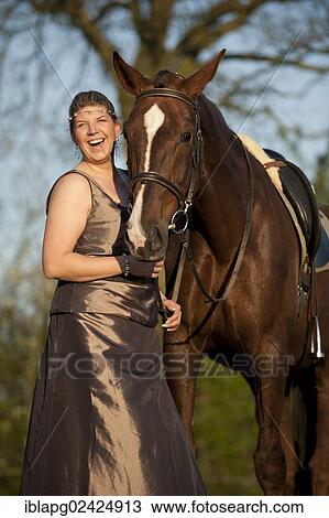 Woman wearing an evening dress standing beside an Oldenburg horse View Large Photo Image Stock Image - Woman wearing an evening dress standing beside an Oldenburg horse. Fotosearch