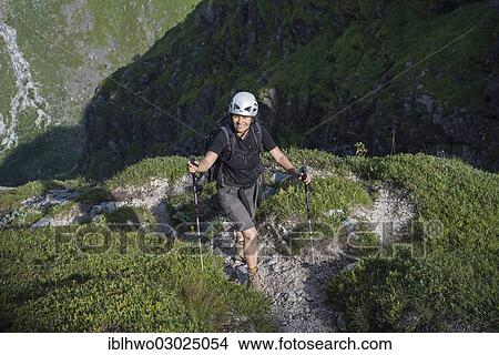 "Woman with a backpack, a rock climbing helmet and hiking poles on the mountain path to the mountain plateau of Lundeskaret, Kommune Jolster, Jostedalsbreen Nationalpark, Sogn og Fjordane, Western Norway, Norway, Europe" View Large Photo Image Picture - "Woman with a backpack, a rock climbing helmet and hiking poles on the mountain path to the mountain plateau of Lundeskaret, Kommune Jolster, Jostedalsbreen Nationalpark, Sogn og Fjordane, Western Norway, Norway, Europe". Fotosearch