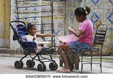 Stock Image - "Woman with a child at a courtyard, Havana, Cuba, North America". Fotosearch