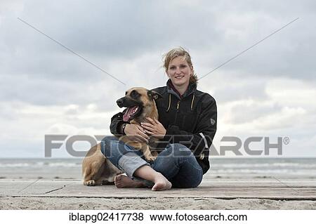 Woman with a Hollandse Herdershond, Dutch Shepherd, sitting on a beach, Sankt Peter-Ording, Schleswig-Holstein, Germany, Europe View Large Photo Image Stock Photo - Woman with a Hollandse Herdershond, Dutch Shepherd, sitting on a beach, Sankt Peter-Ording, Schleswig-Holstein, Germany, Europe. Fotosearch
