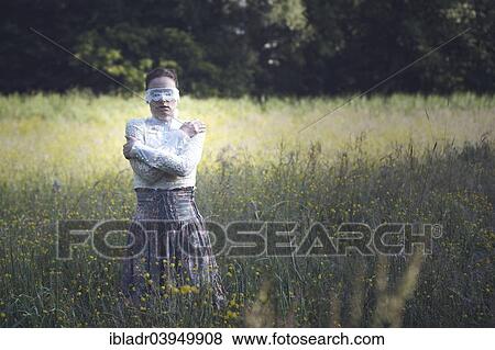 Woman with a lace mask in front of her eyes standing in a meadow View Large Photo Image Stock Photo - Woman with a lace mask in front of her eyes standing in a meadow. Fotosearch