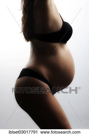 Stock Image - Woman with a pregnant belly in underwear. Fotosearch