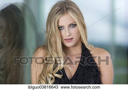 "Woman with long blond hair leaning against a glass wall, portrait" View Large Photo Image Stock Image - "Woman with long blond hair leaning against a glass wall, portrait". Fotosearch