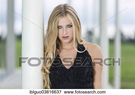 Stock Photo - "Woman with long blond hair leaning against a column, portrait". Fotosearch