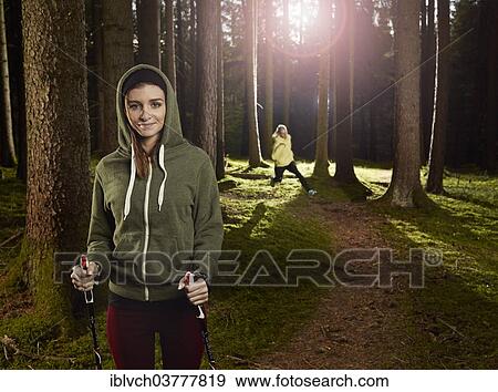 "Woman with Nordic Walking sticks in the forest, another woman jogging at back, Tyrol, Austria, Europe" View Large Photo Image Stock Photo - "Woman with Nordic Walking sticks in the forest, another woman jogging at back, Tyrol, Austria, Europe". Fotosearch