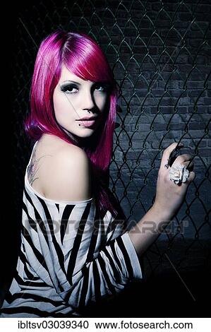 Woman with pink hair in front of a chain link fence View Large Photo Image Stock Image - Woman with pink hair in front of a chain link fence. Fotosearch