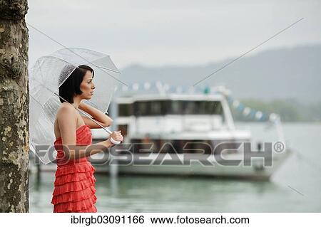 "Woman with umbrella outside in a summer rain, Lake Constance, Lindau - Bodensee, Bavaria, Germany, Europe" View Large Photo Image Stock Photograph - "Woman with umbrella outside in a summer rain, Lake Constance, Lindau - Bodensee, Bavaria, Germany, Europe". Fotosearch
