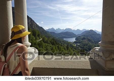 Stock Image - "Woman with views from the balcony, Neuschwanstein Castle, Schwangau, Ostallgau, Allgau, Swabia, Bavaria, Germany, Europe". Fotosearch