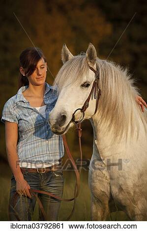 "Woman with Welsh Pony, white horse, gelding, on meadow in the evening light" View Large Photo Image Stock Image - "Woman with Welsh Pony, white horse, gelding, on meadow in the evening light". Fotosearch