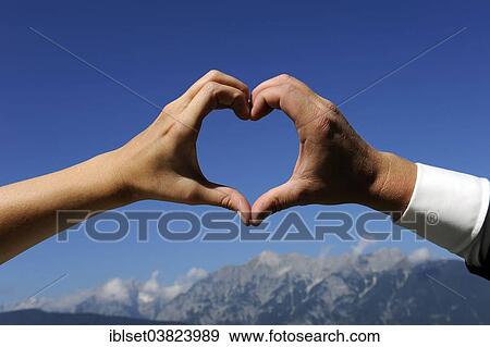 Woman's hand and man's hand forming a heart against a blue sky View Large Photo Image Stock Photo - Woman's hand and man's hand forming a heart against a blue sky. Fotosearch