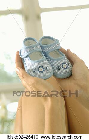 Woman's hands are holding baby shoes View Large Photo Image Stock Image - Woman's hands are holding baby shoes. Fotosearch