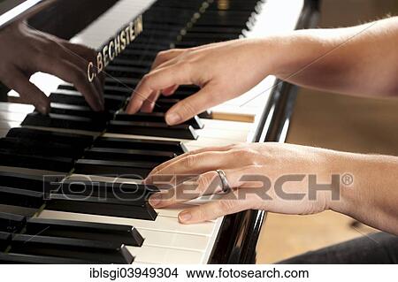 Picture - Woman's hands playing a Bechstein grand piano. Fotosearch