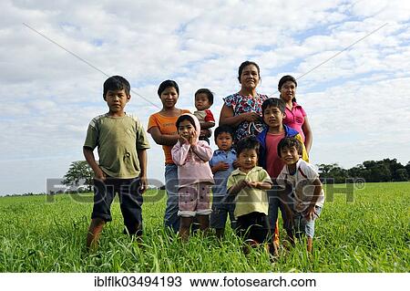 Stock Image - "Women and children of an indigenous community of Guarani Indians in a field, until recently the land belonged to the village, now it is claimed by the Mennonites, Jaguary, Caaguazu Department, Paraguay, South America". Fotosearch