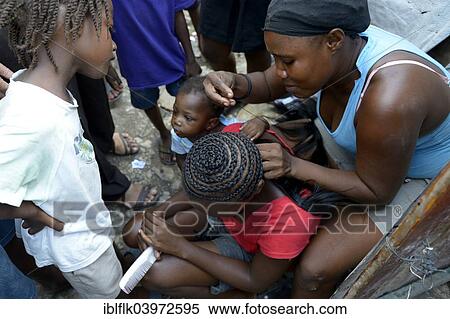 Stock Photography - "Women braiding plaits, Camp Icare, camp for earthquake refugees, Fort National, Port-au-Prince, Haiti, North America". Fotosearch