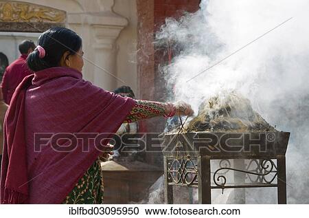 Stock Image - "Women burning incence in front of Boudnath Stupa, Kathmandu Valley, Kathmandu, Kathmandu District, Bagmati Zone, Nepal, Asia". Fotosearch