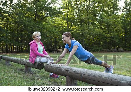 Women exercising on an outdoor fitness trail View Large Photo Image Stock Image - Women exercising on an outdoor fitness trail. Fotosearch