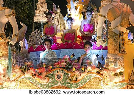 Stock Image - "Women in traditional costume travelling on a float, parade, Loi Krathong Festival of Lights, Loy, Chiang Mai, Northern Thailand, Thailand, Asia". Fotosearch