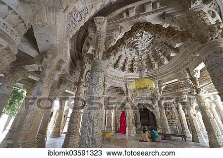 Stock Image - "Women sitting in the Interior hall with ornate pillars and ceilings in the marble temple, Adinatha Temple, temple of the Jain religion, Ranakpur, Rajasthan, India, Asia". Fotosearch