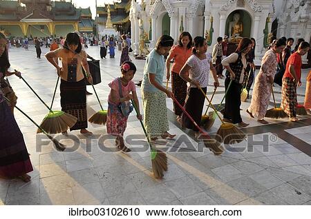 Stock Image - "Women sweeping the floor as a ritual action, Shwedagon Pagoda, Yangon, Yangon Region, Myanmar, Burma, Asia". Fotosearch
