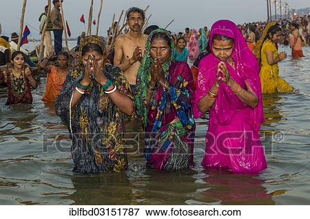 Stock Photo - "Women taking a bath in the Sangam, the confluence of the rivers Ganges, Yamuna and Saraswati, in the early morning, Kumbha Mela mass Hindu pilgrimage, Allahabad, Uttar Pradesh, India, Asia". Fotosearch