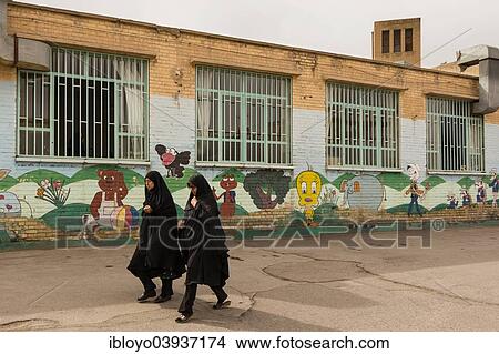 Picture - "Women wearing Chador passing a kindergarten, Yazd, Kashan, Iran, Asia". Fotosearch