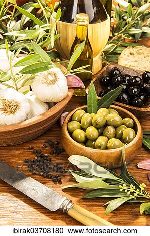 "Wooden bowls with green and black olives, garlic, olive branches, Germany, Europe" View Large Photo Image Stock Image - "Wooden bowls with green and black olives, garlic, olive branches, Germany, Europe". Fotosearch