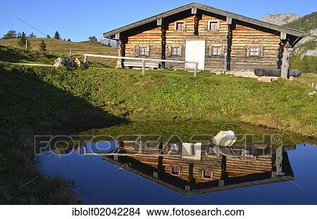 Picture - "Wooden cabin reflected in a small pond, Gotzenalm alp, Schoenau, Koenigssee, Berchtesgadener Land, Bavaria, Germany, Europe". Fotosearch