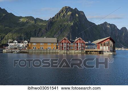 Stock Image - "Wooden houses at the harbor entrance of Svolvaer, mountain range at back, Svolvaer, Kommune Vagan, Insel Austvagoya, Inselgruppe Lofoten, Nordland, Northern Norway, Norway, Europe". Fotosearch