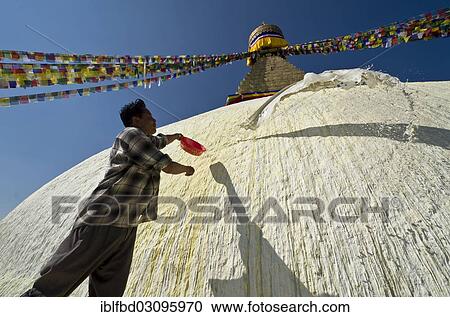 Stock Image - "Worker renewing the white paint of Boudnath Stupa, Kathmandu Valley, Kathmandu, Kathmandu District, Bagmati Zone, Nepal, Asia". Fotosearch