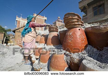 Stock Image - "Worker sorting out pottery after the burning process, Kathmandu Valley, Thimi, Kathmandu District, Bagmati Zone, Nepal, Asia". Fotosearch