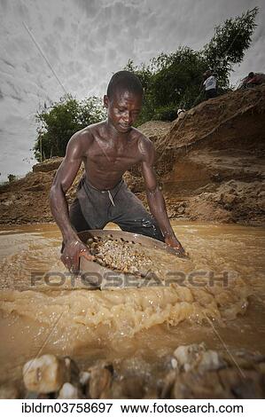 Stock Photo - "Worker washing gravel at a diamond mine, Kenema, Eastern Province, Sierra Leone, Africa". Fotosearch
