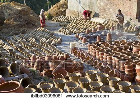 Stock Image - "Workers sorting out pottery after the burning process, Kathmandu Valley, Thimi, Kathmandu District, Bagmati Zone, Nepal, Asia". Fotosearch