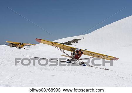 "Yellow light aircrafts parking on a snowy slope on Moenchsjoch, Canton Bern, Switzerland, Europe" View Large Photo Image Stock Image - "Yellow light aircrafts parking on a snowy slope on Moenchsjoch, Canton Bern, Switzerland, Europe". Fotosearch