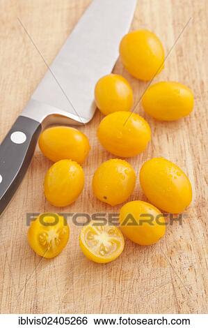Yellow plum tomatoes and a kitchen knife on a cutting board View Large Photo Image Stock Photograph - Yellow plum tomatoes and a kitchen knife on a cutting board. Fotosearch