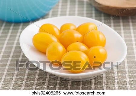 Yellow plum tomatoes on a white plate View Large Photo Image Stock Photography - Yellow plum tomatoes on a white plate. Fotosearch
