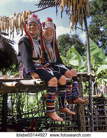 Stock Photo - "Young Akha girls in a mountain village, in traditional costume and headdress, Chiang Rai Province, Northern Thailand, Thailand, Asia". Fotosearch
